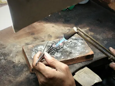 Ourives a soldar fio de prata, técnica da filigrana
